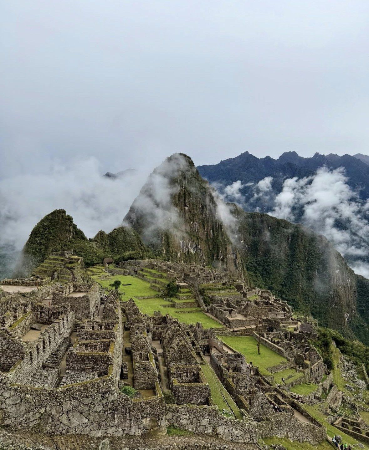 Mist drifting around Huayna Picchu above the terraced Inca ruins